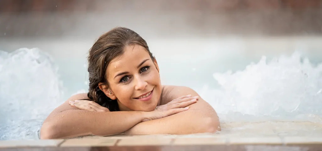 Eine Frau lächelte in die Kamera im Wasser am Beckenrand